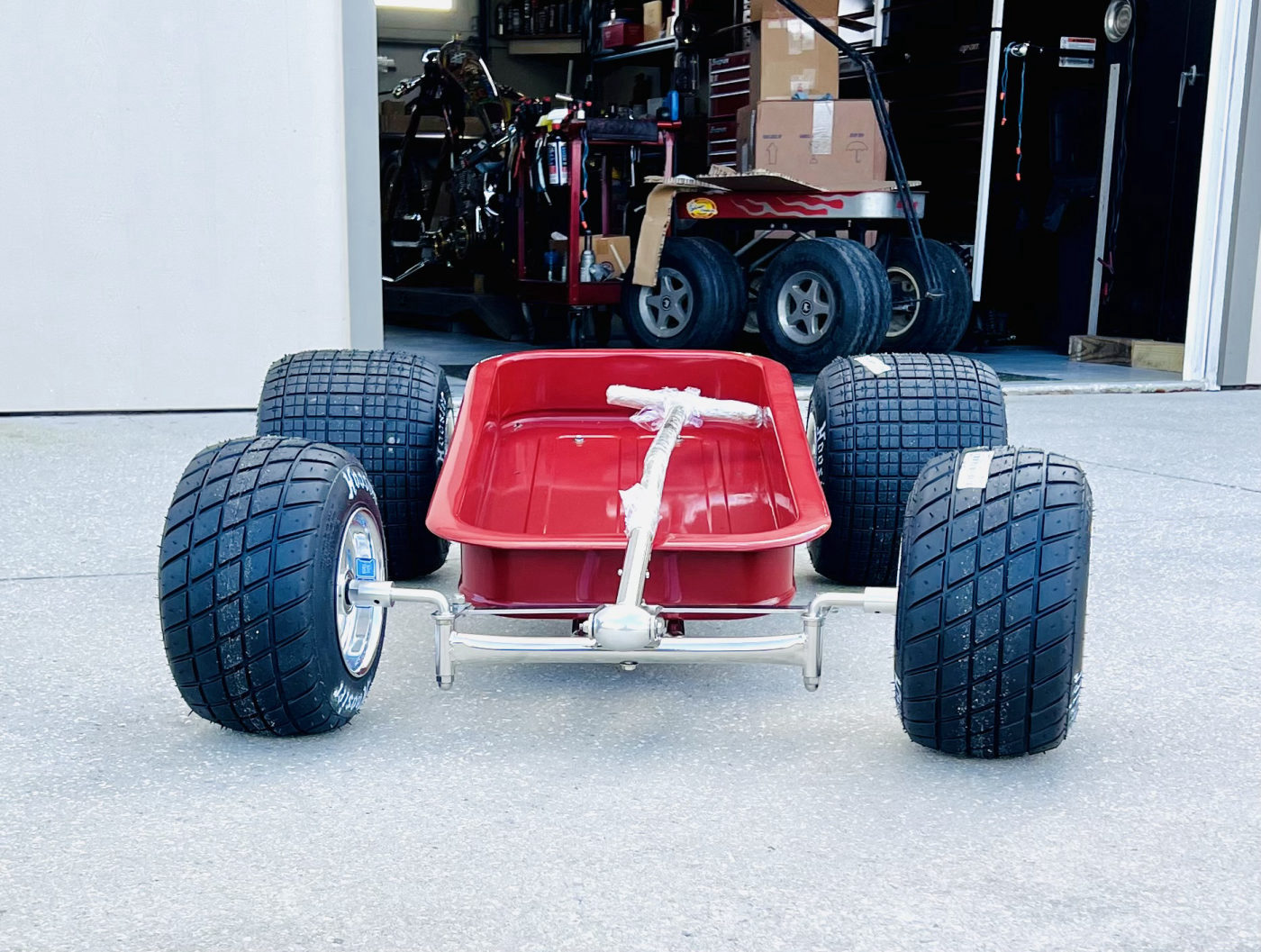 DKCC Hot Rod Flyer — shop build shot on lift showing Radio Flyer body and custom chassis mid-assembly