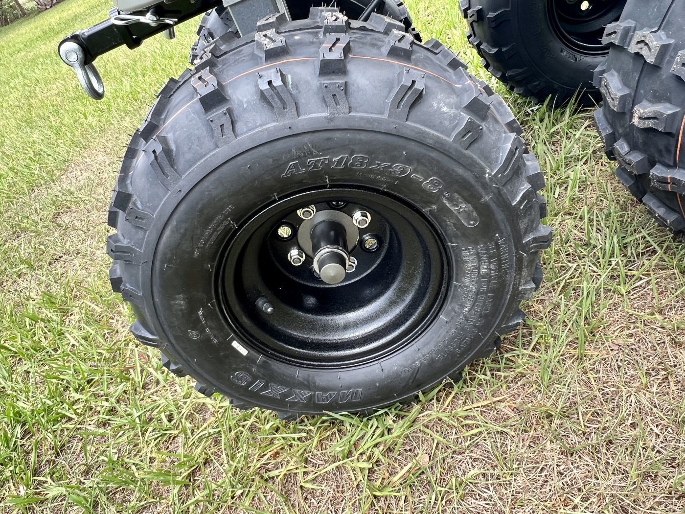DKCC Bigfoot Flyer — close-up of Maxxis AT18x9-8 tire and black steel wheel